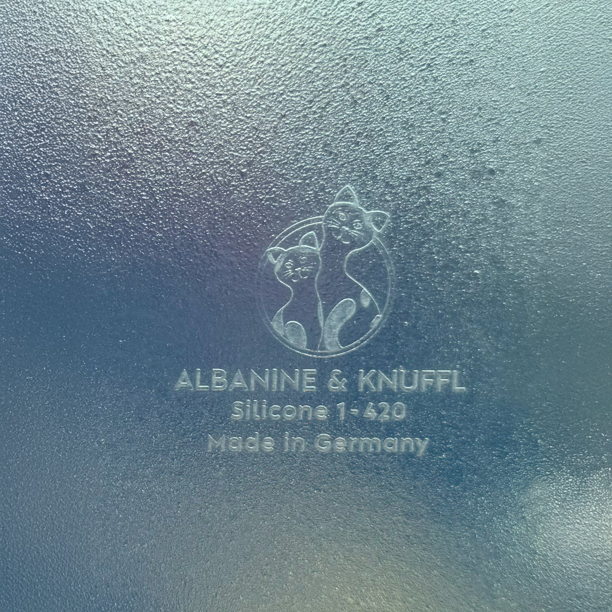 Nahaufnahme Bodenmarke auf Rückseite 8-eckiger farbloser Silikonunterlage für Katzengeschirr, Länge 52,5 cm und Breite 52,5 cm