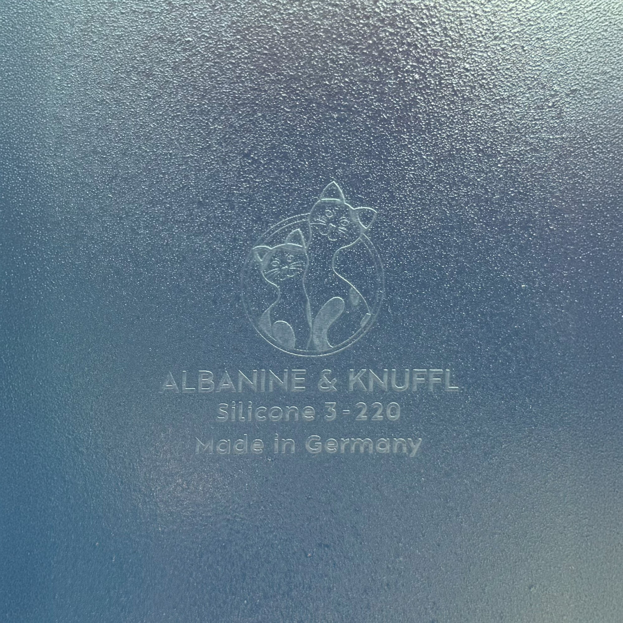 Nahaufnahme Bodenmarke auf Rückseite 8-eckiger farbloser Silikonunterlage für Katzengeschirr, Länge 81,5 cm und Breite 30,5 cm