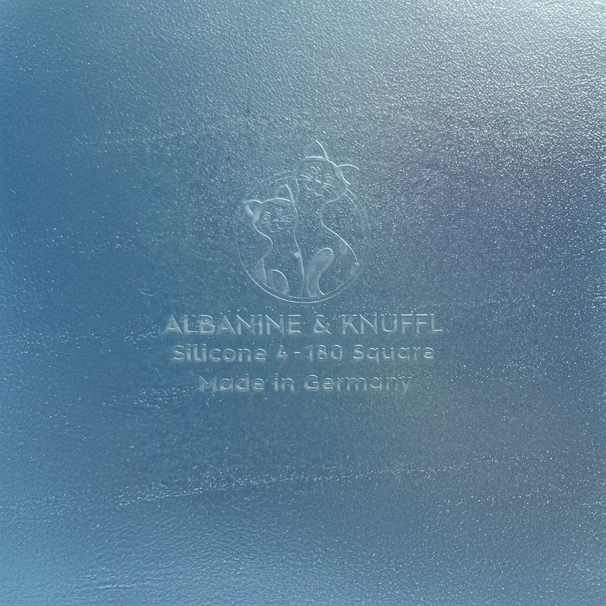 Nahaufnahme Bodenmarke auf Rückseite 8-eckiger farbloser Silikonunterlage für Katzengeschirr, Länge 45 cm und Breite 45 cm