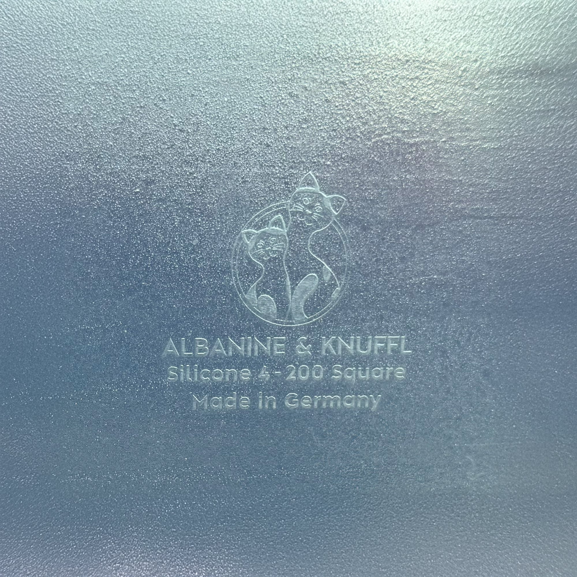 Nahaufnahme Bodenmarke auf Rückseite 8-eckiger farbloser Silikonunterlage für Katzengeschirr, Länge 50,5 cm und Breite 50,5 cm