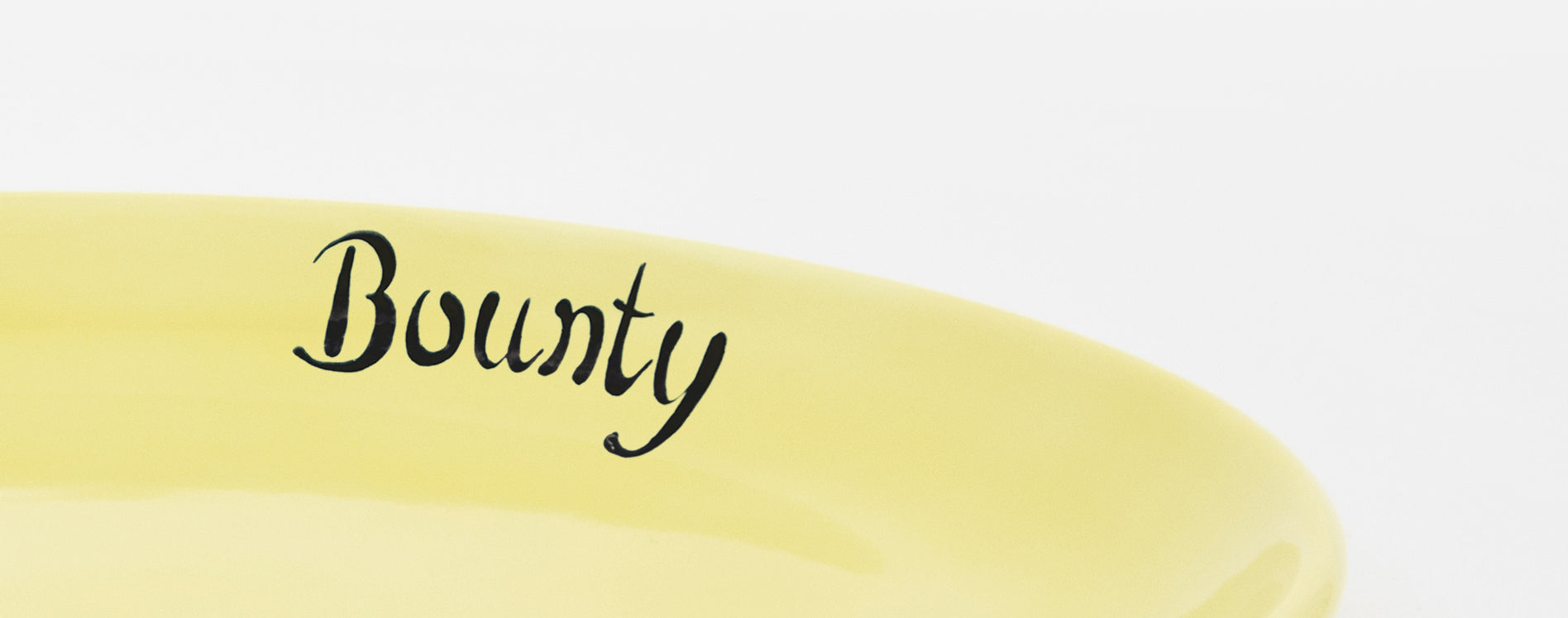 Close-up detail of the inner rim of a yellow cat plate with personalised inscription in black