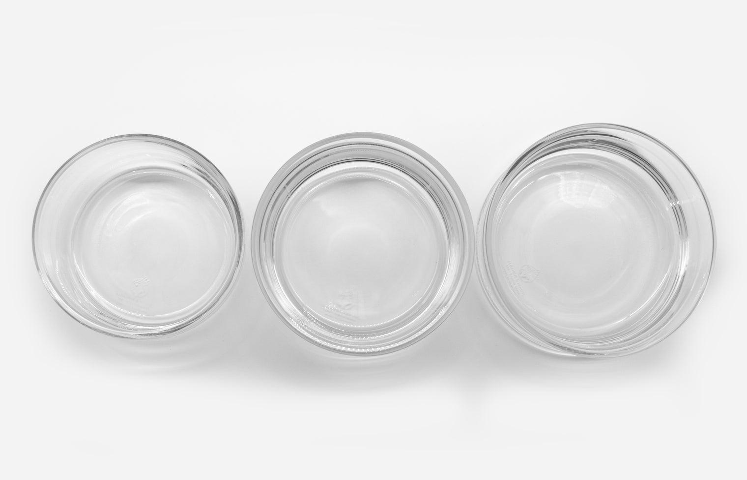 3 Trinkschalen für Katzen aus farblosem Glas nebeneinander in den 3 verschiedenen Größen von Albanine & Knuffl – Ansicht von oben